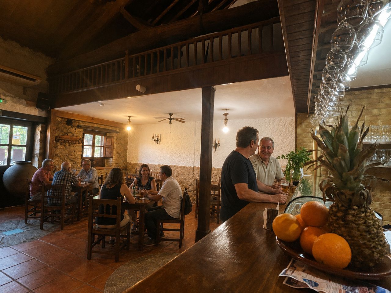 El Molino's bar counter with glassware hanging overhead, regulars chatting and the timber-beamed dining room behind